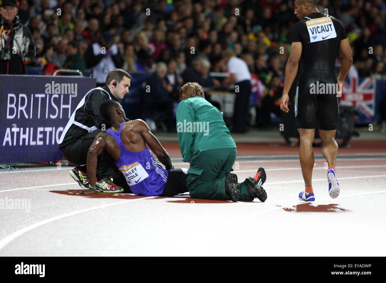 London, UK. 24th July, 2015. Kemar Bailey-Cole (JAM) with medics after he sustained an injury in the mens 100m final during the Sainsbury’s Anniversary Games Diamond League event at The Queen Elizabeth Olympic Park on July 24, 2015 in London, UK Credit:  Grant Burton/Alamy Live News Stock Photo