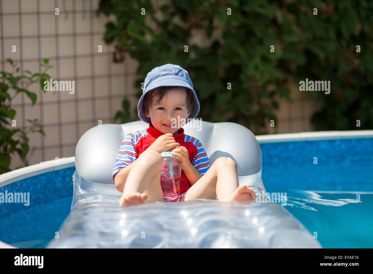 Sweet little boy, swimming in big swimming pool, summertime Stock Photo