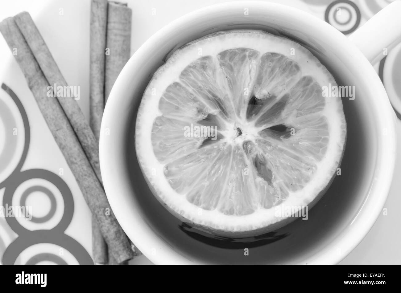 Tea in white mug with slice of lemon and cinnamon on white background Stock Photo