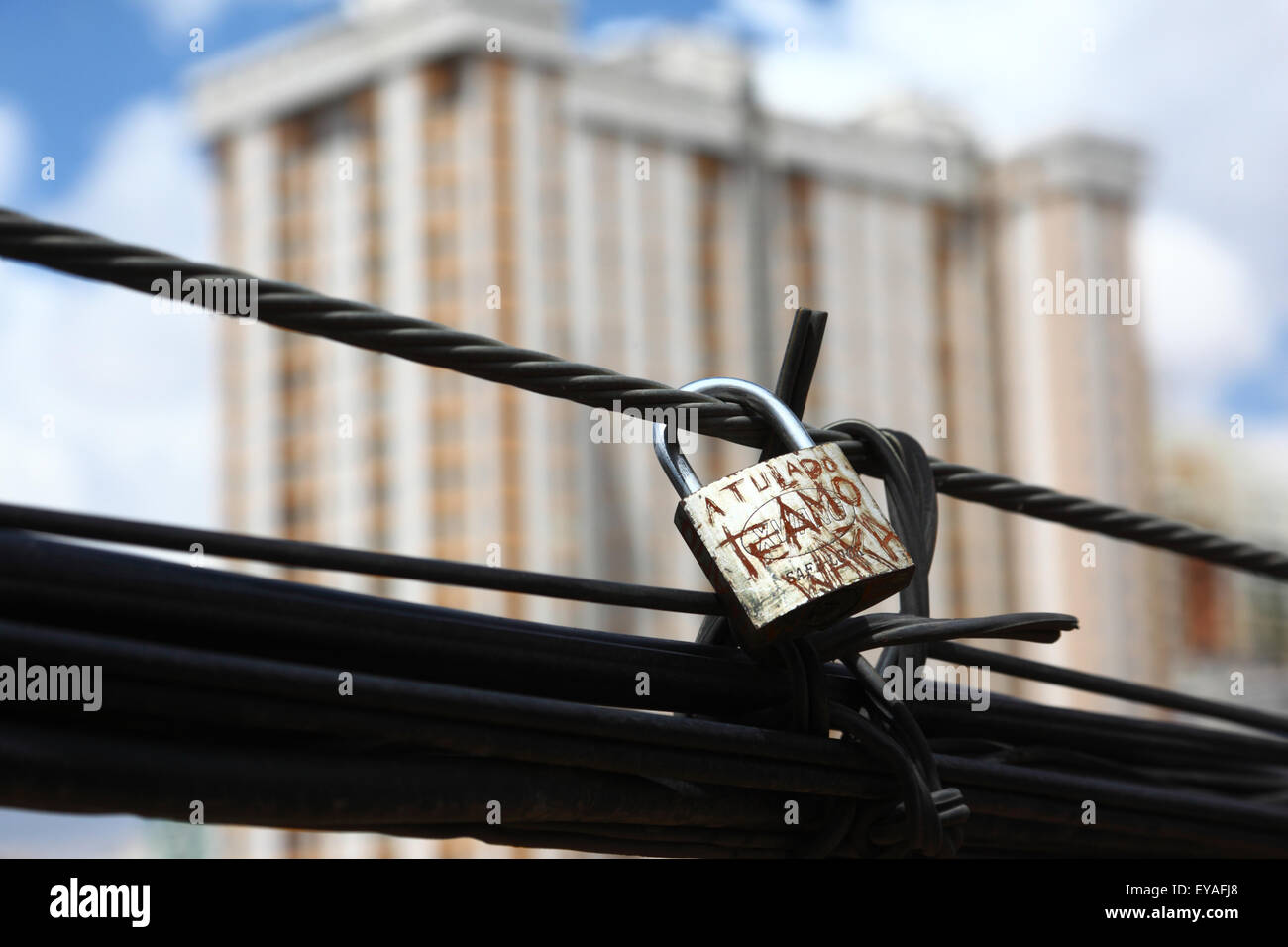 Love locks on cable next to Las Americas bridge and high rise building, La Paz, Bolivia Stock Photo