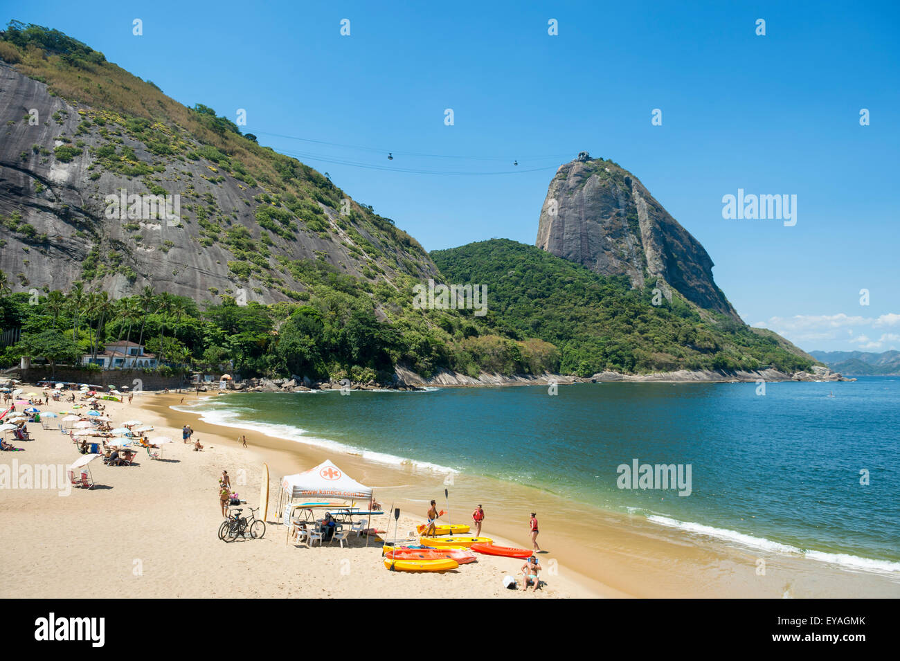RIO DE JANEIRO, BRAZIL - MARCH 24, 2015: Sunbathers relax on Praia Vermelha Red Beach under Sugarloaf Mountain. Stock Photo