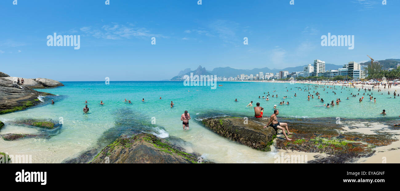 RIO DE JANEIRO, BRAZIL - JANUARY 17, 2015: Beachgoers take advantage of calm seas at the Arpoador end of Ipanema Beach. Stock Photo