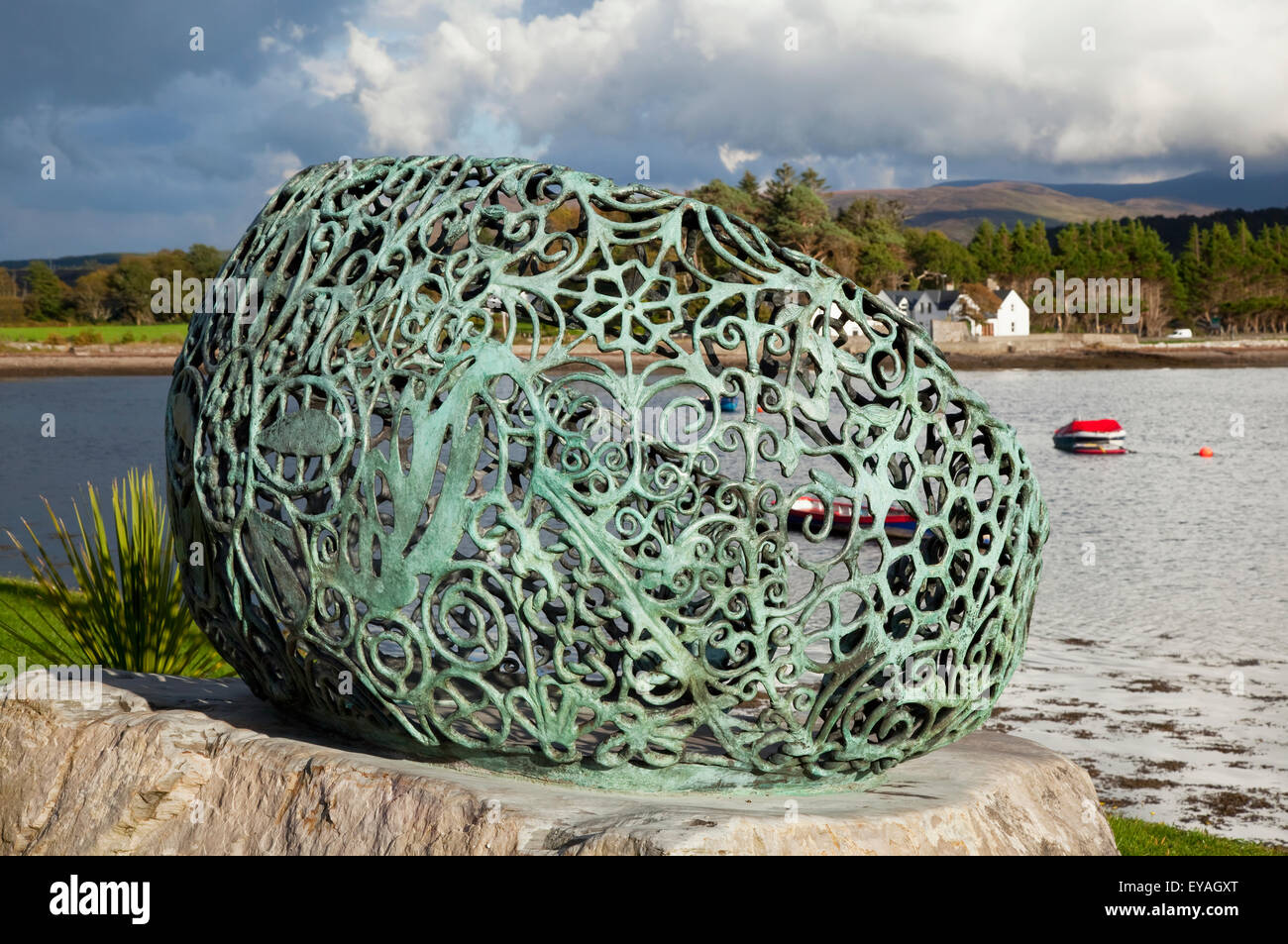 Green metal sculpture on a rock beside the beach; Kenmare, County Kerry ...
