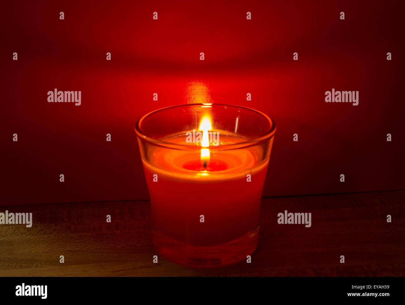Candle with red background Stock Photo - Alamy
