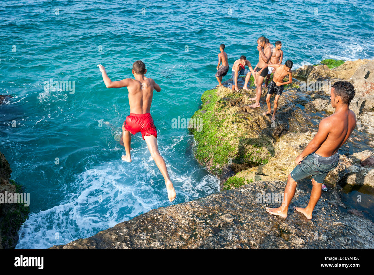HAVANA, CUBA - MAY 23, 2011: Young Cubans take turns jumping into the ...