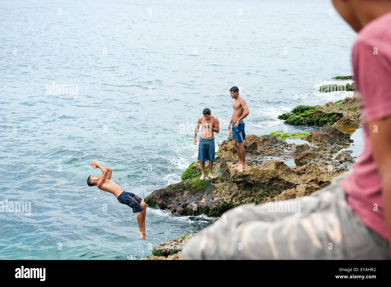 HAVANA, CUBA - MAY 23, 2011: Young Cubans take turns jumping into the sea at a popular swimming hole called Cueva del Tiburon. Stock Photo