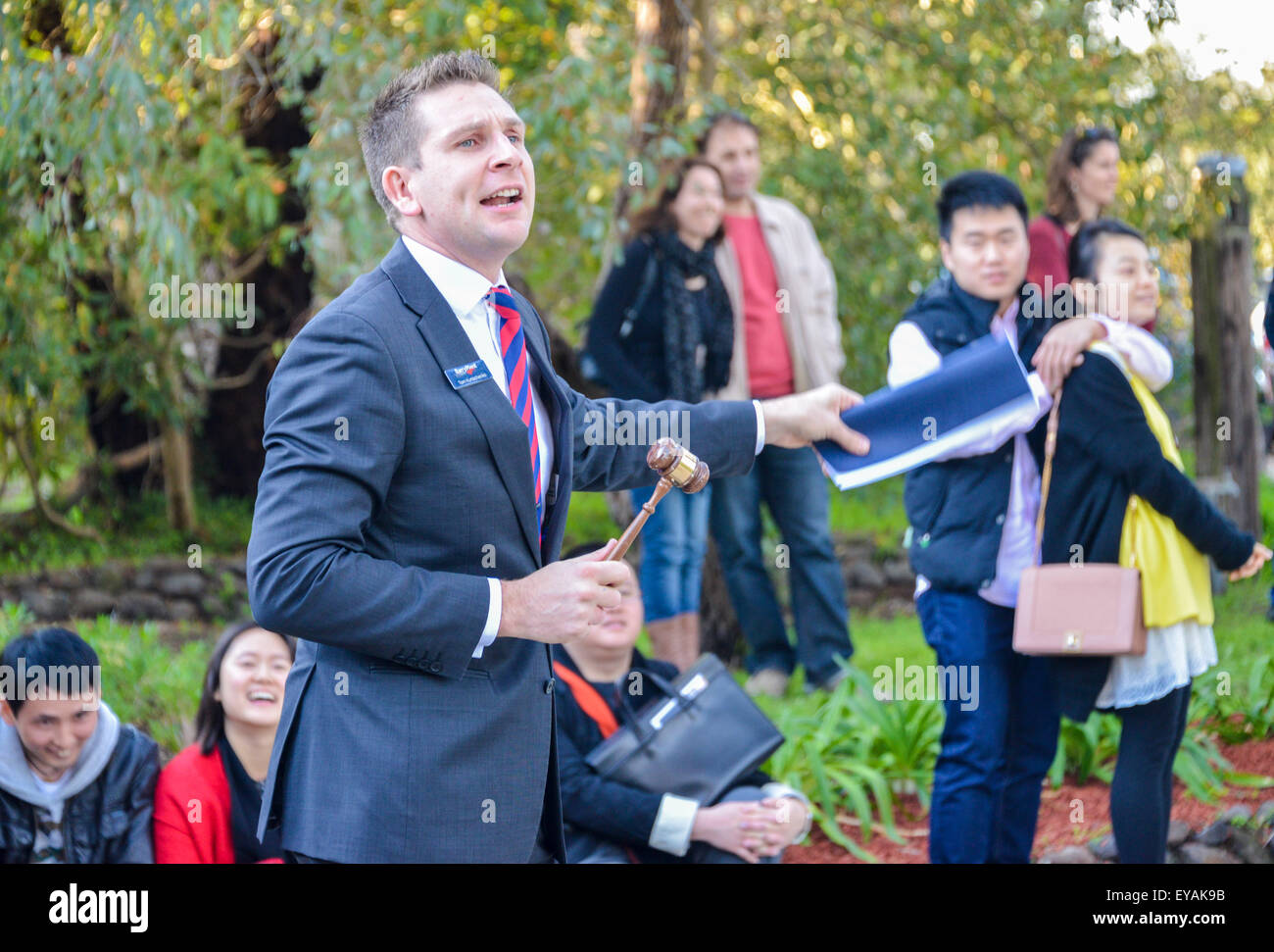 Auctioneer with gabble selling property with chinese, asians and westerners bidding at the Auction Stock Photo