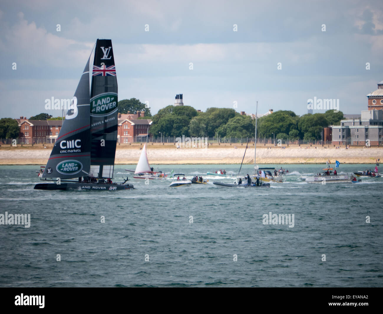 Portsmouth, England, July 25th 2015. The Ben Ainslie Racing catamaran is followed into the solent by a flotilla of small craft prior to the first day of racing of the Americas Cup World Series in Portsmouth. The Americas Cup World Series takes place in Portsmouth between the 23 July and the 26th July 2015 Credit:  simon evans/Alamy Live News Stock Photo
