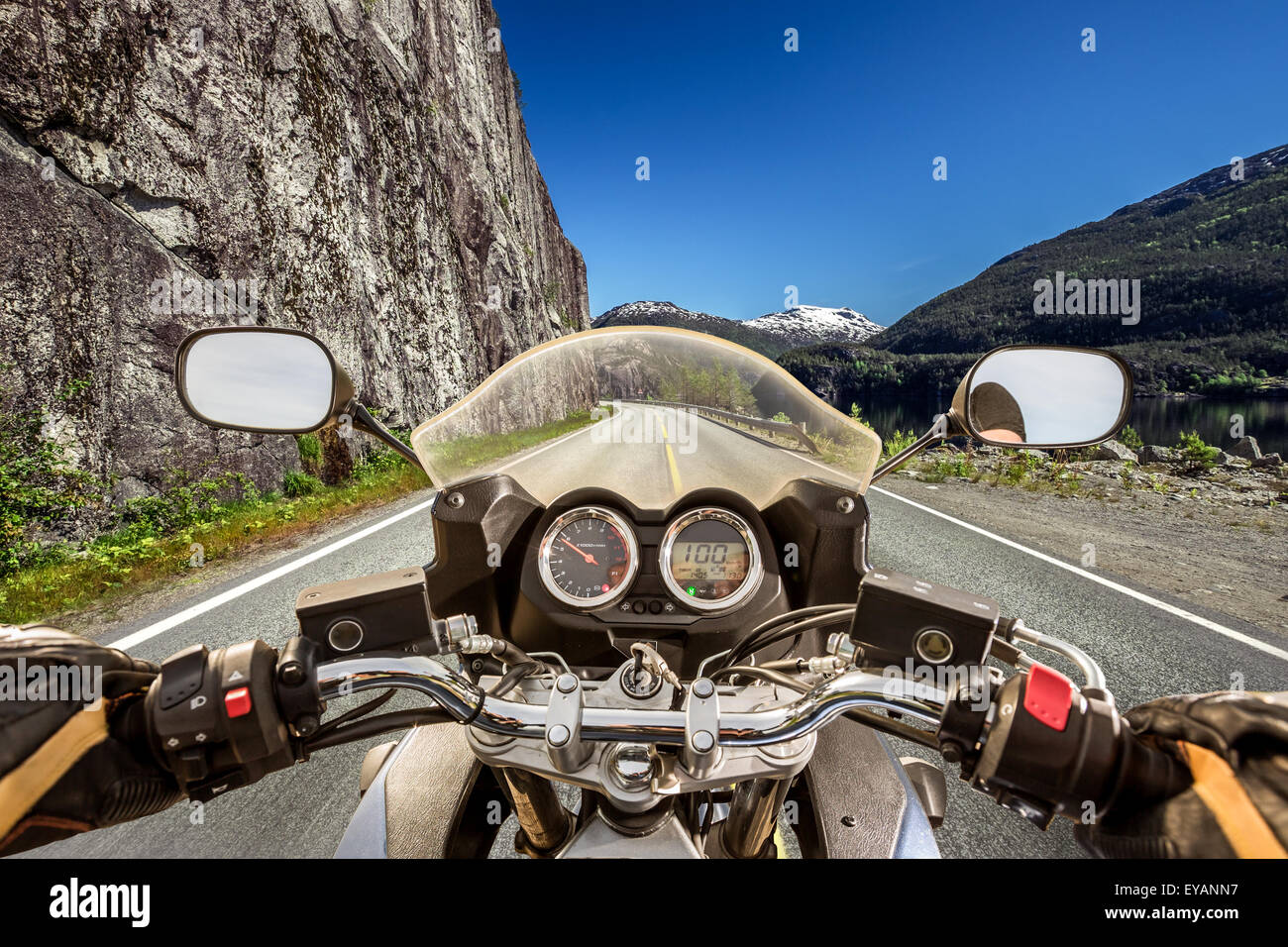 Biker rides a motorcycle on mountain serpentine. First-person view. Stock Photo