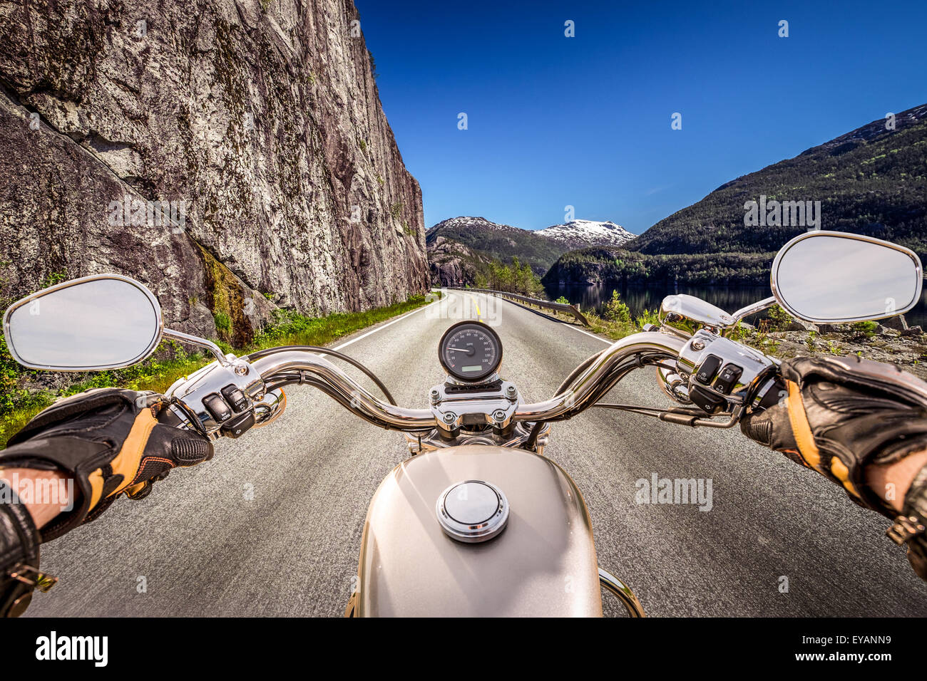 Biker rides a motorcycle on mountain serpentine. First-person view. Stock Photo