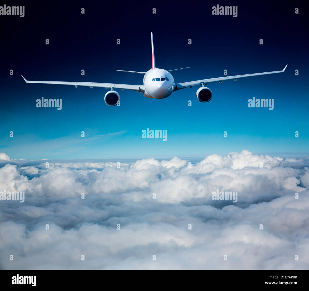 Passenger Airliner flying in the clouds Stock Photo