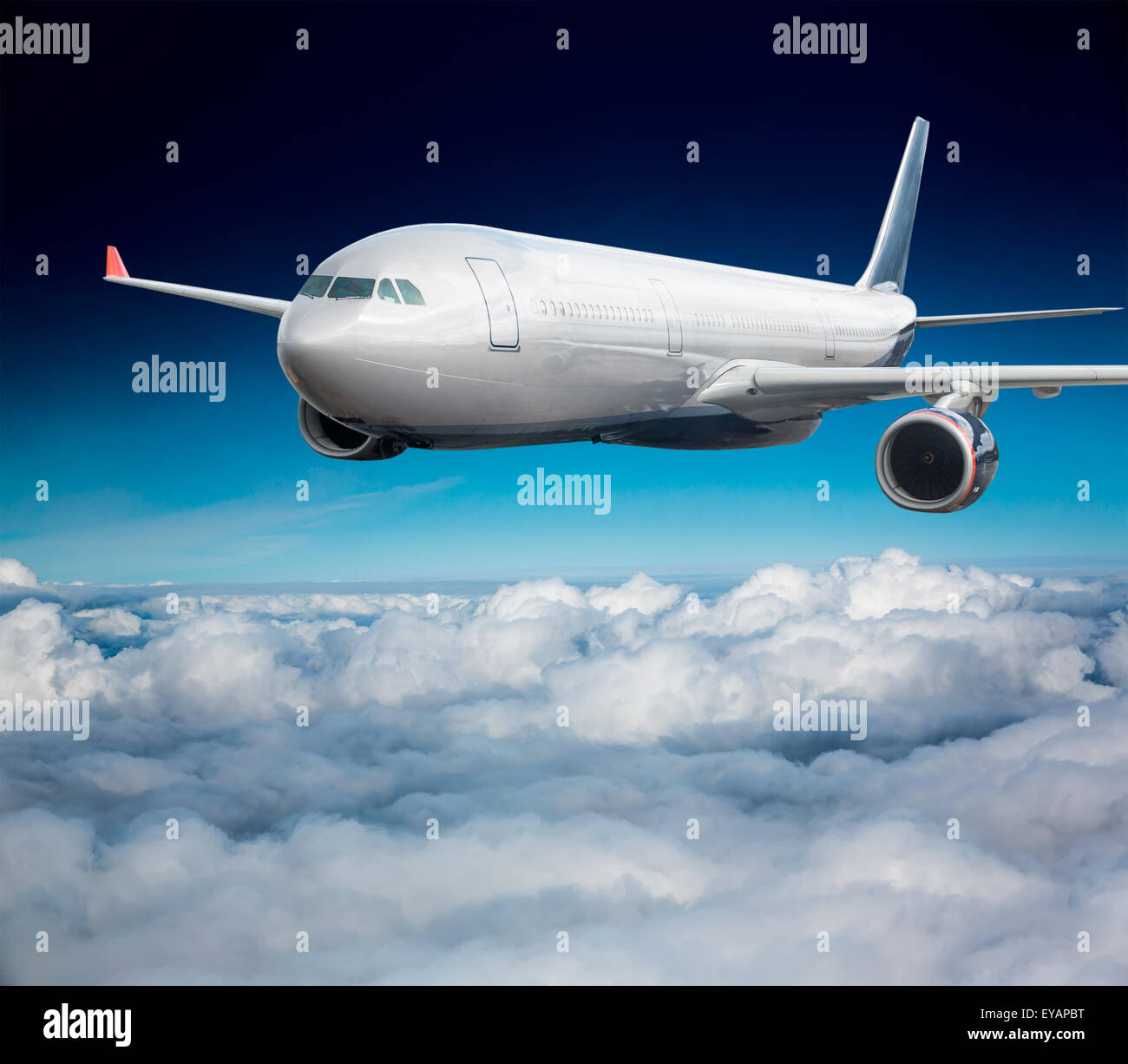 Passenger Airliner flying in the clouds Stock Photo