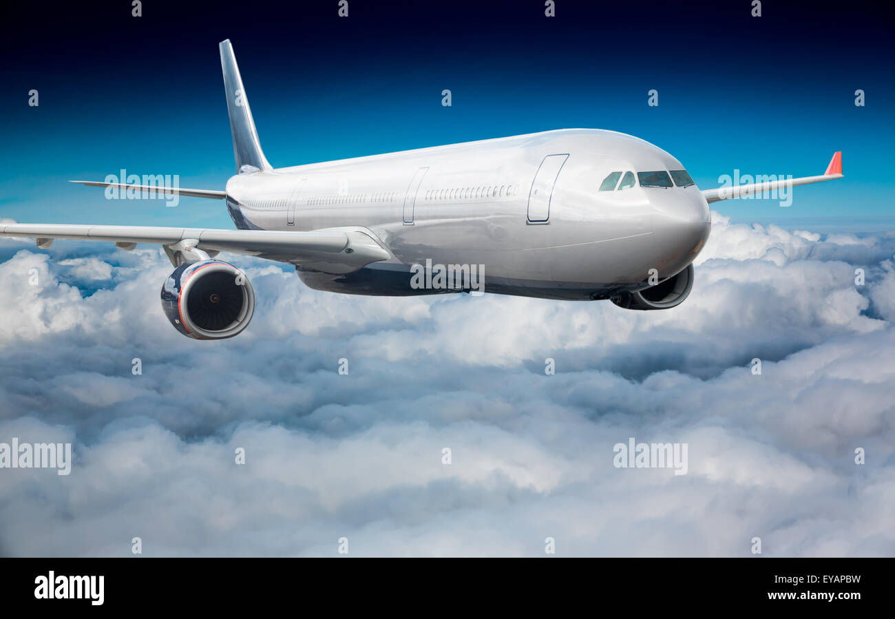 Passenger Airliner flying in the clouds Stock Photo