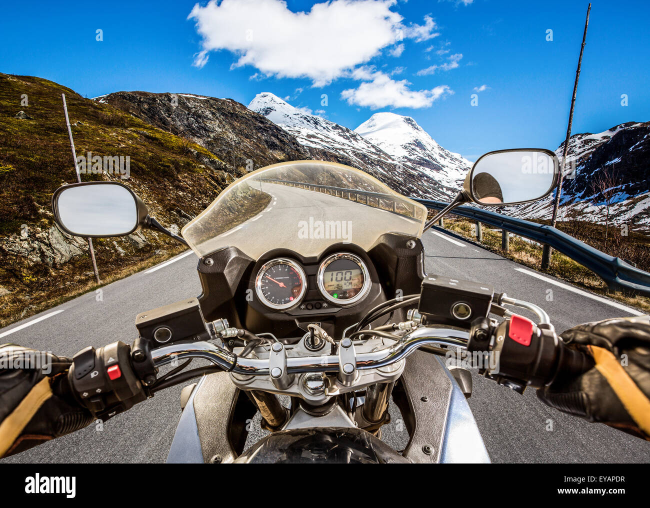 Biker rides a motorcycle on mountain serpentine. First-person view. Stock Photo