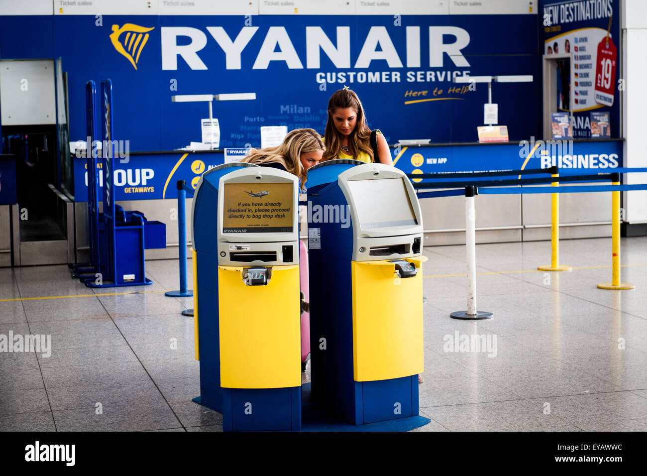 Passengers using Automatic Check In machines next to Ryanair Customer Service at Stansted airport, uk Stock Photo