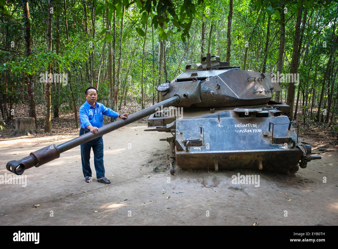 A Vietnamese man holds the barrel of a tank at the Cu Chi Tunnels in Vietnam Stock Photo