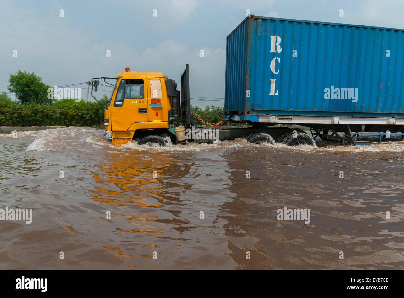 A container truck moving through floodwater on Prof. Dr. Ir. Soedijatmo Toll Road in Jakarta, Indonesia. Stock Photo