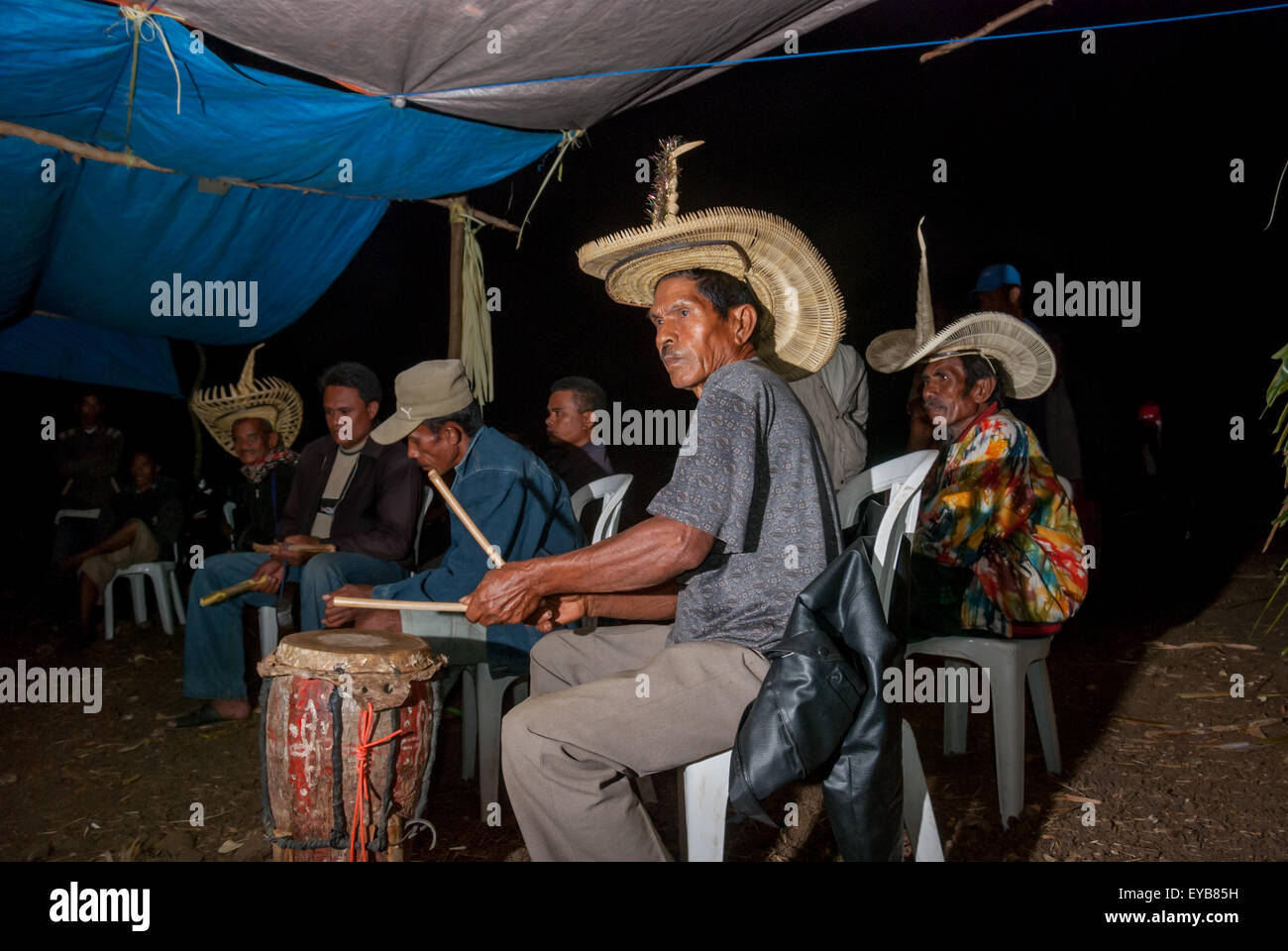 Community Playing Instruments Men playing percussive instruments during a community gathering in ...