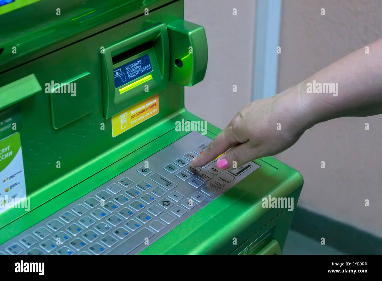 The hand of man (woman) is gaining PIN code on the keypad of the ATM terminal Stock Photo