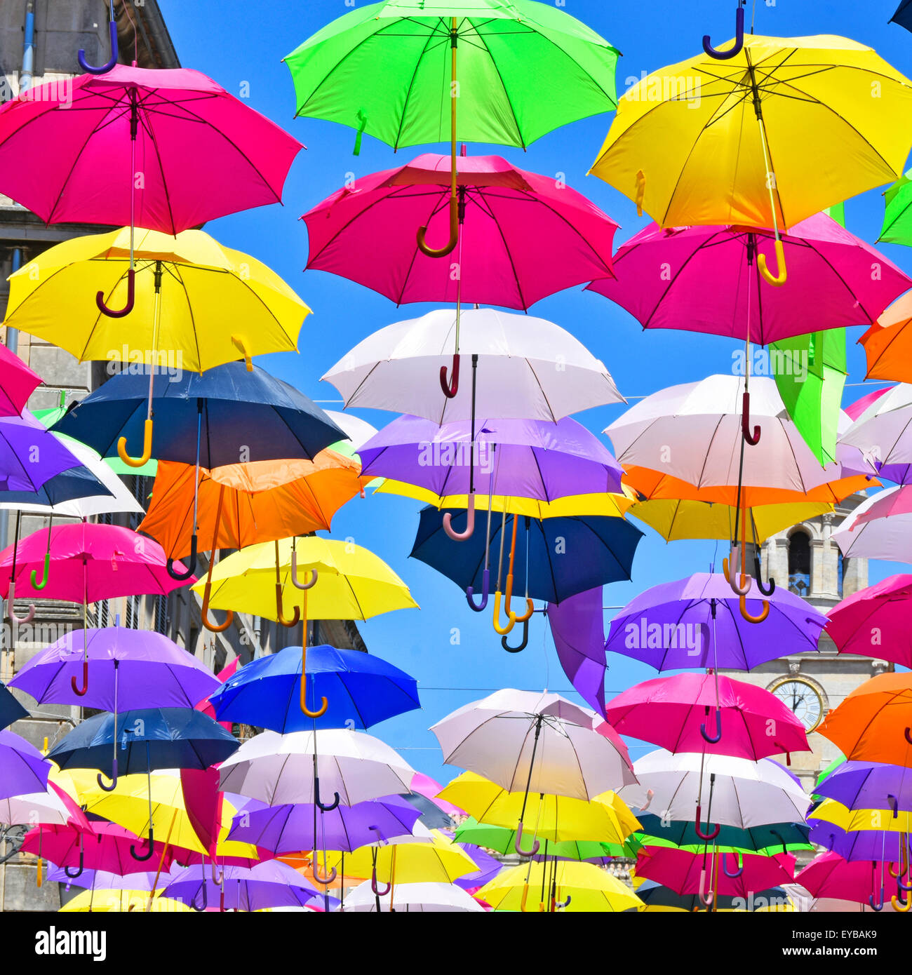 Sunshine blue sky & parasol umbrella colours close up in street art display in the ancient French City of Arles France Provence Stock Photo
