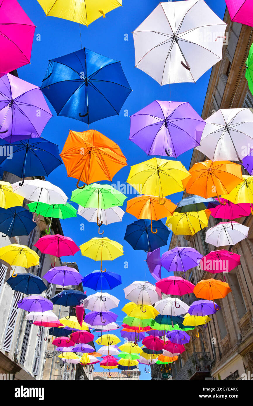 Blue sky & parasol umbrella colours in street art display in the ancient French City of Arles France Provence Stock Photo