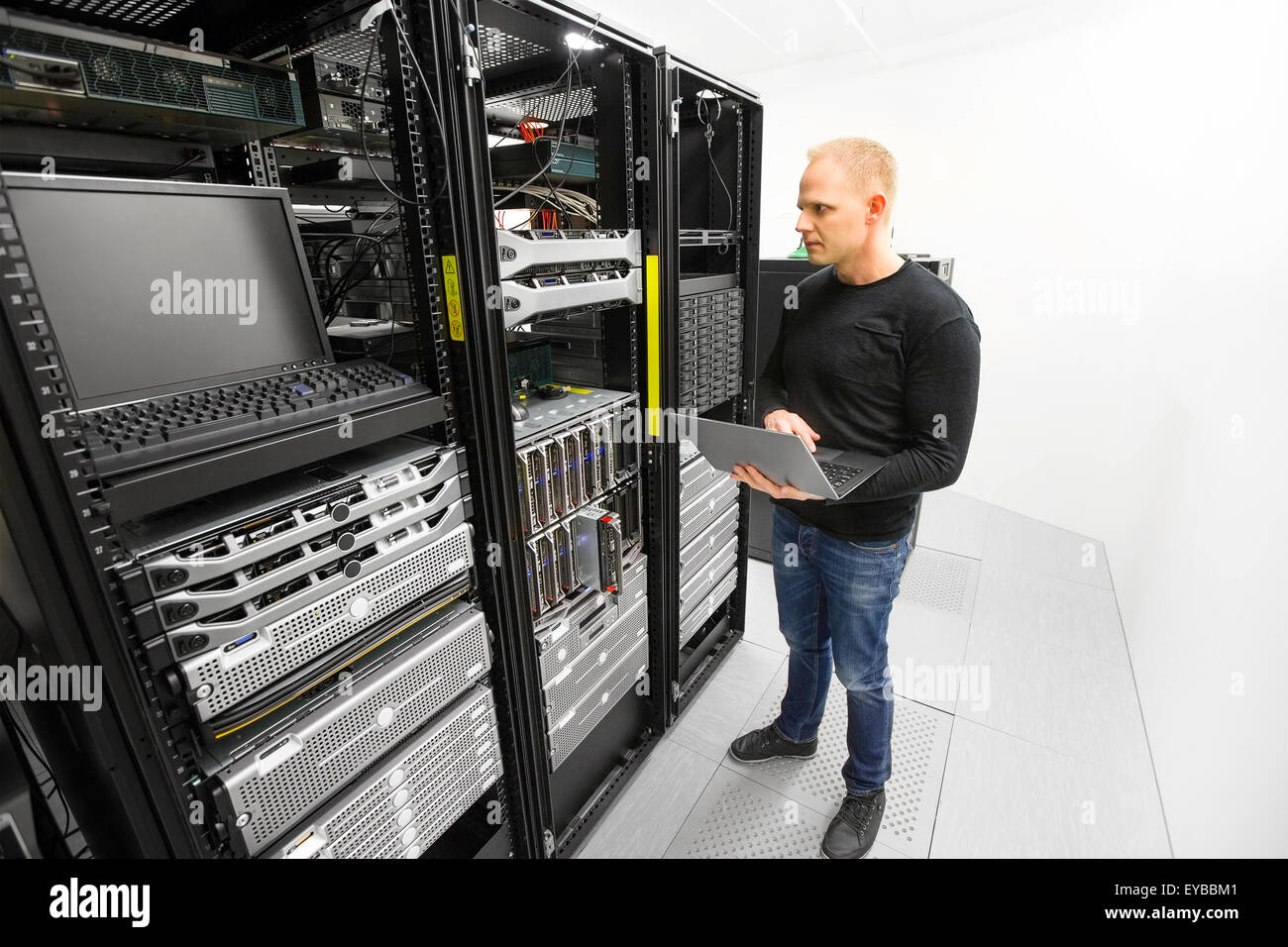 It engineer maintains servers in datacenter Stock Photo