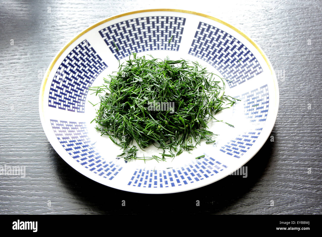 fresh chopped dills on plate with blue design Stock Photo