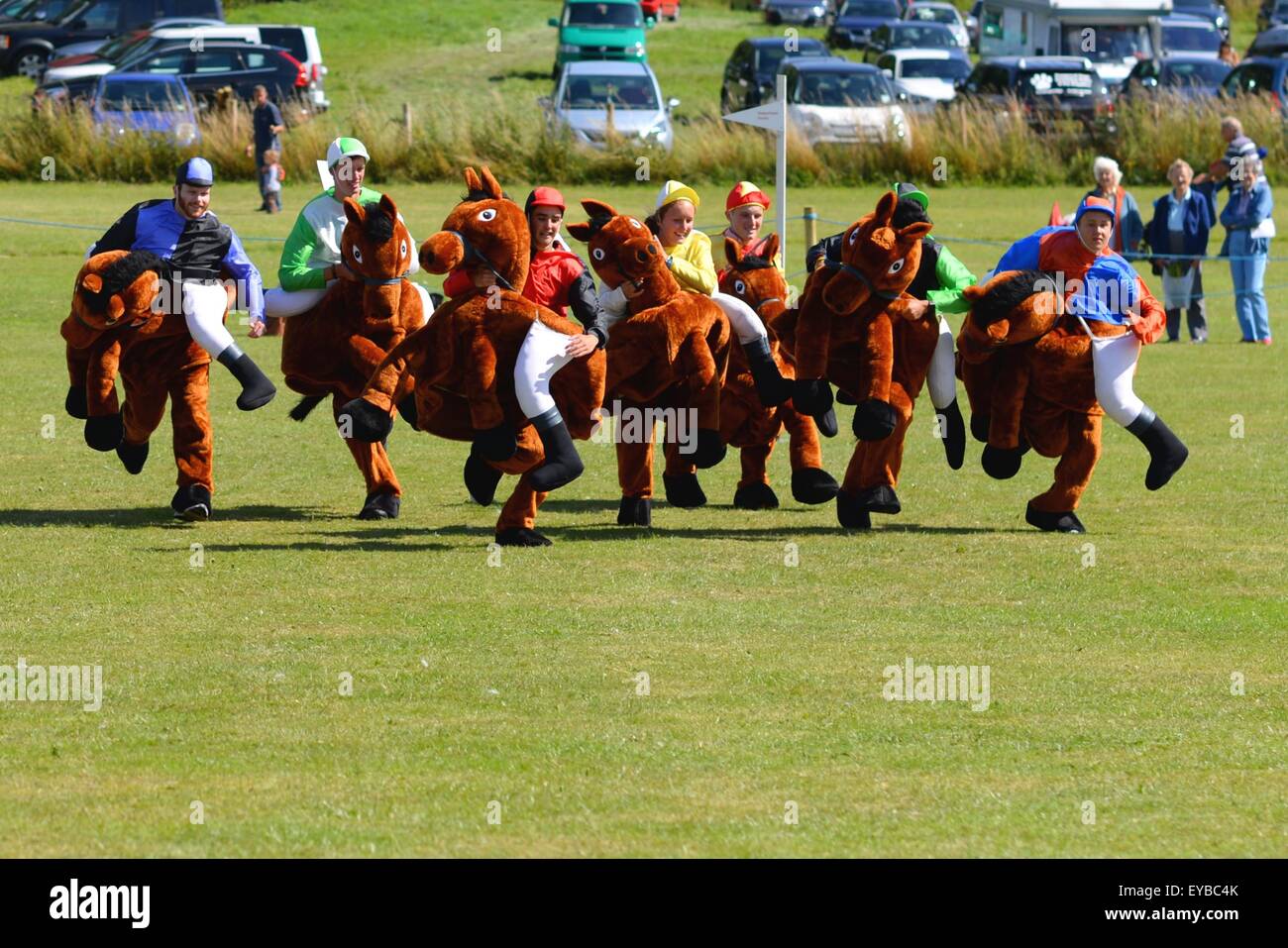 Horses and jockeys racing in the Damerham Derby fancy dress horse race at the Damerham Fair and Horticultural Show, Hampshire, UK Stock Photo