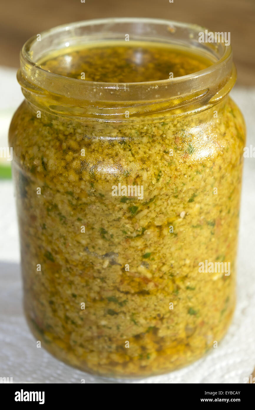 a jar of homemade sicilian pesto with pinenuts basil dry tomatoes and oil Stock Photo