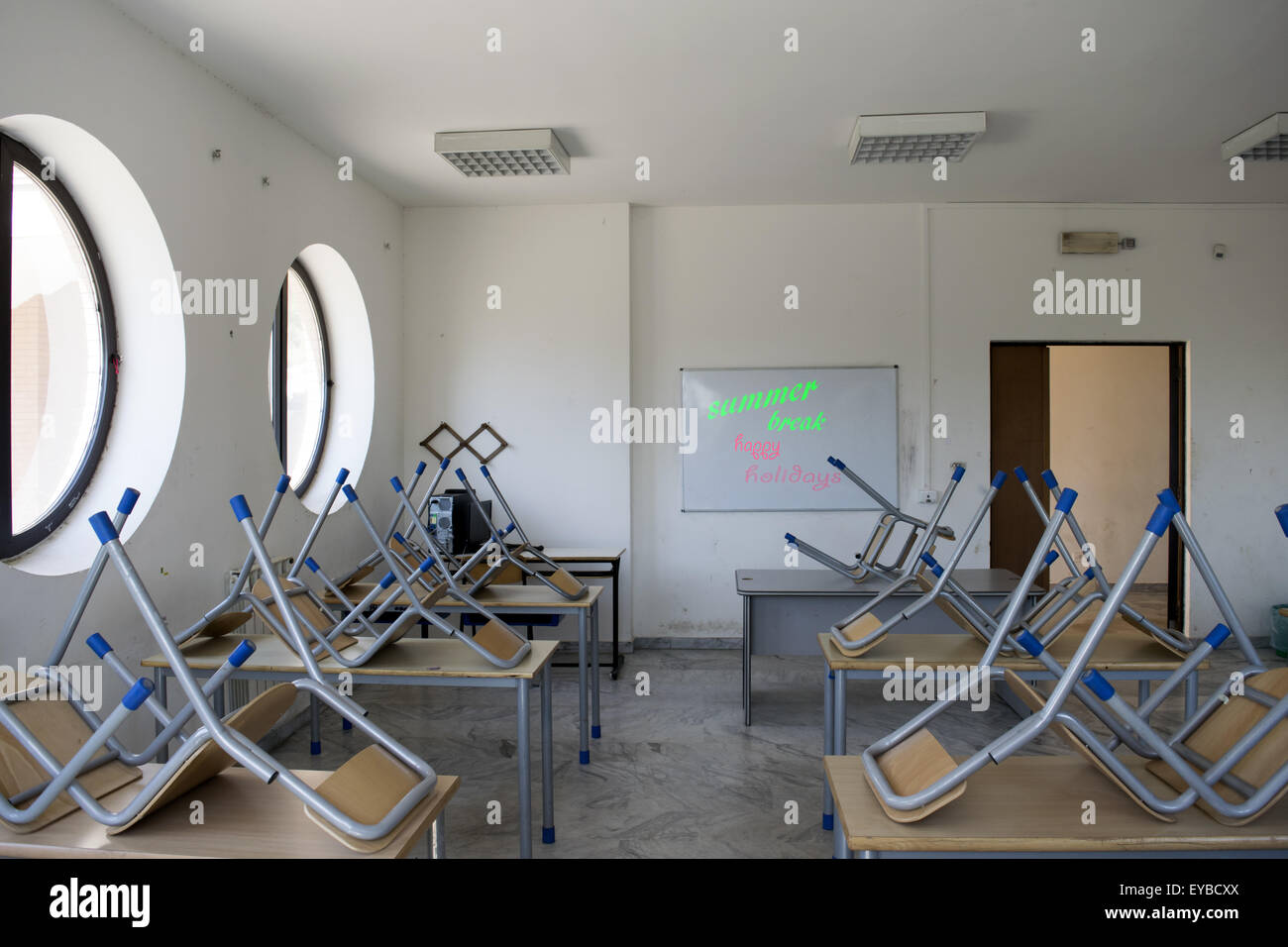 A whiteboard in a scholastic classroom with the message 'summer break happy holidays' written with red and green marker symboliz Stock Photo