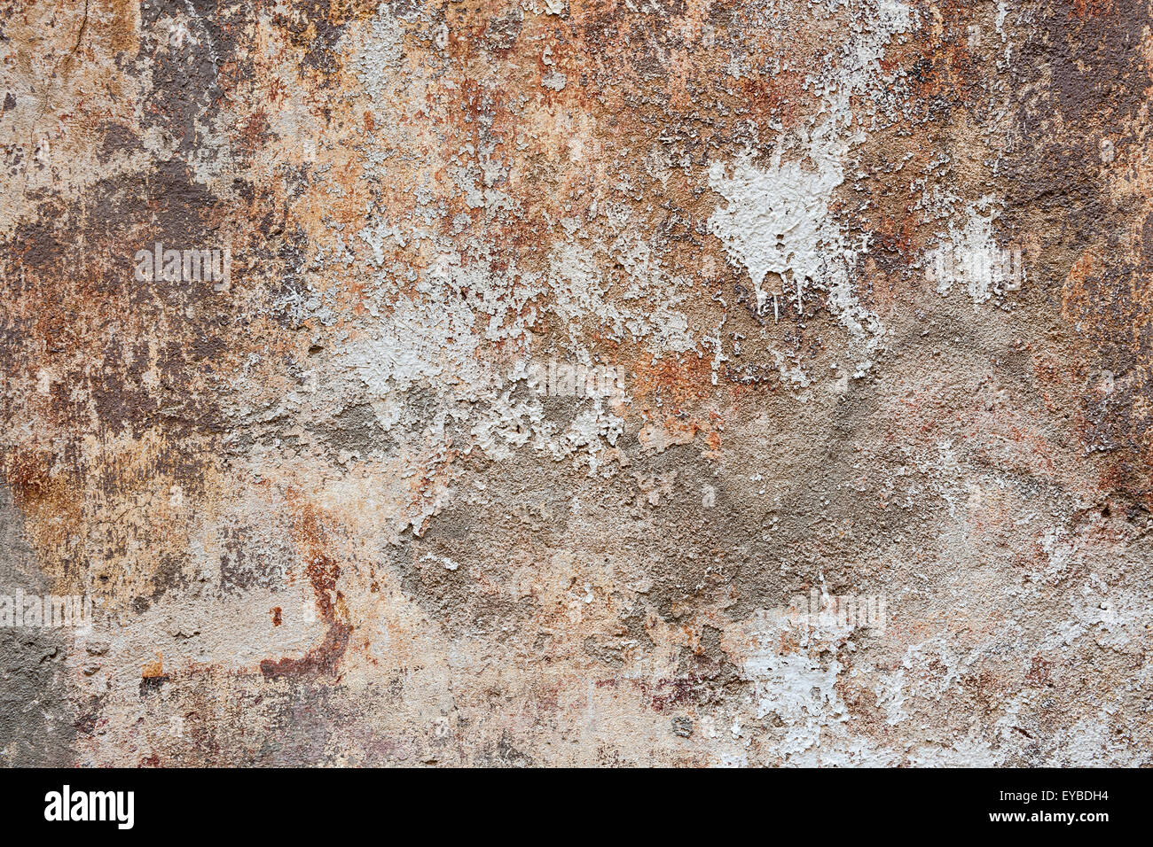 Abstract background of old painted plastered wall with peeling paint texture in brown, grey, and orange colors Stock Photo