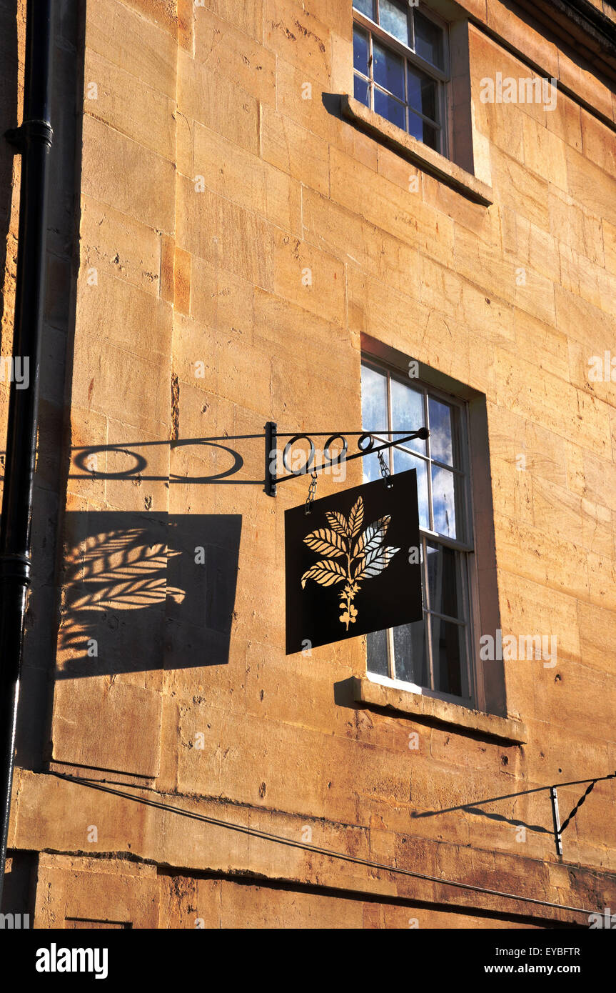 shop sign and its shadow against a wall in Bath, Somerset Stock Photo