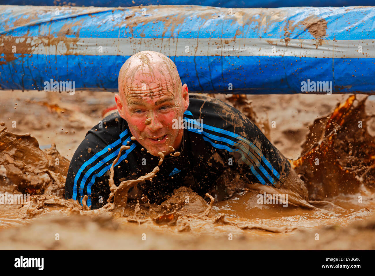 Larry McLellan traverses under a pole and through the water at the Mud Run for Heart July 25, 2015, Waterford, Canada. Stock Photo