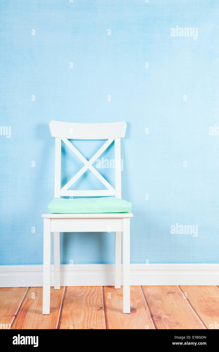 Empty chair on blue wall in interior Stock Photo