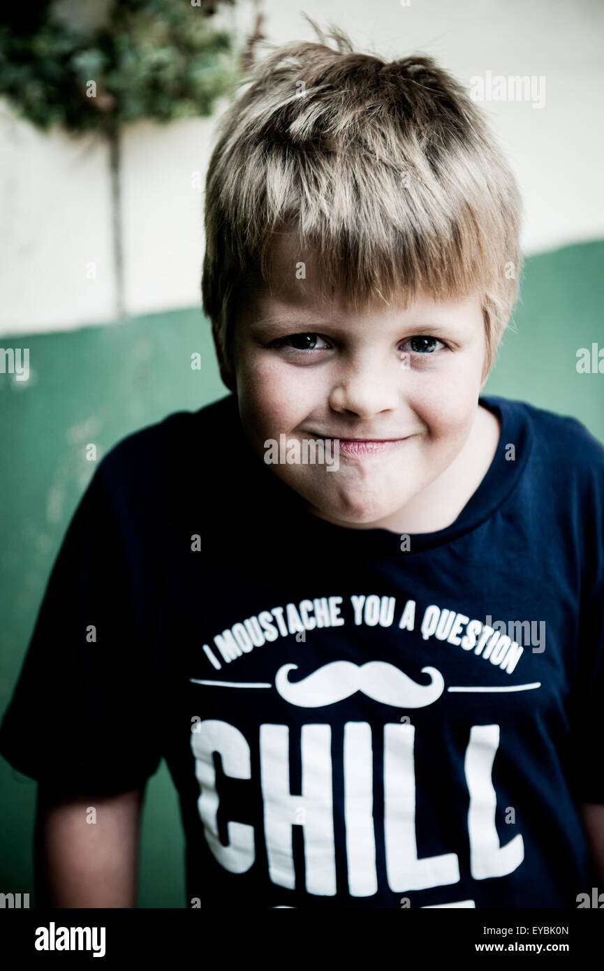 7 8 9 year old boy pulling a silly face with a t shirt saying chill Stock Photo