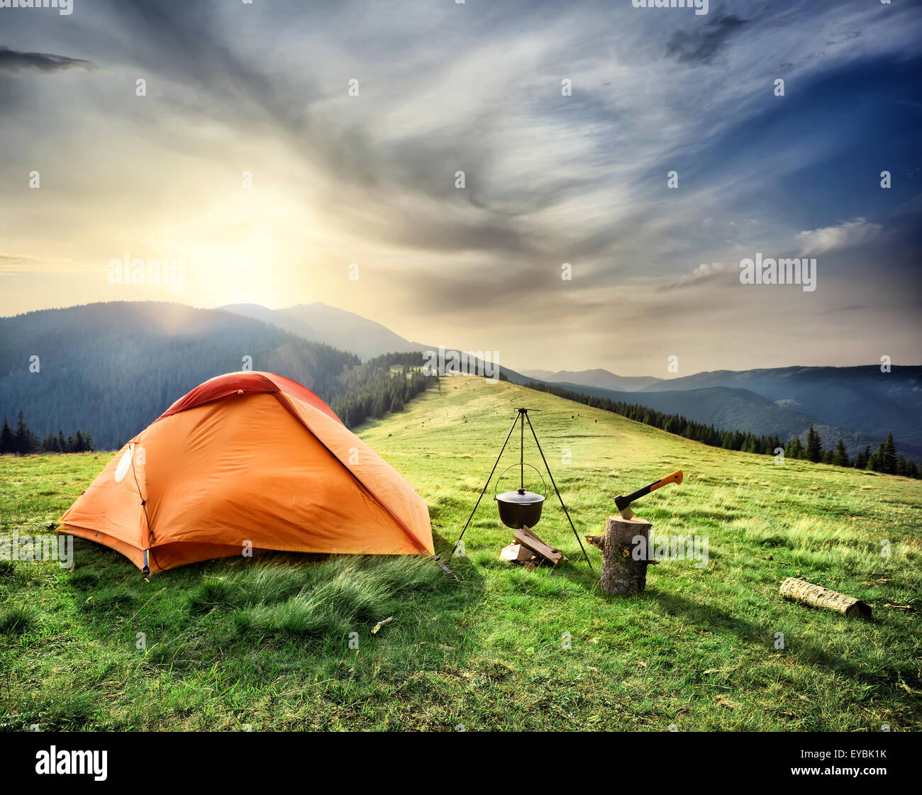 Tent on the hill beneath the mountains under dramatic sky Stock Photo ...