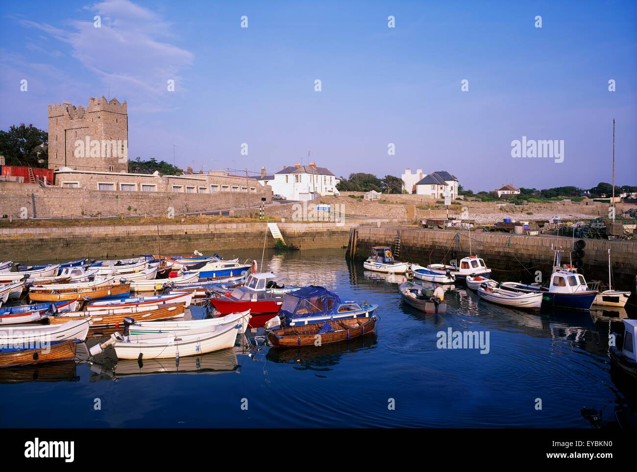 Bullock Harbour, Co Dublin, Ireland; Fishing Boats In A Harbour With A Castle In The Distance