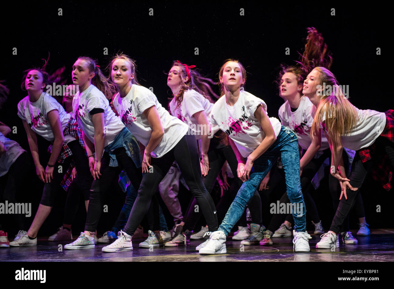 A group of teenage girls performing choreographed modern urban dance routines on stage at Aberystwyth Arets Centre Wales UK Stock Photo