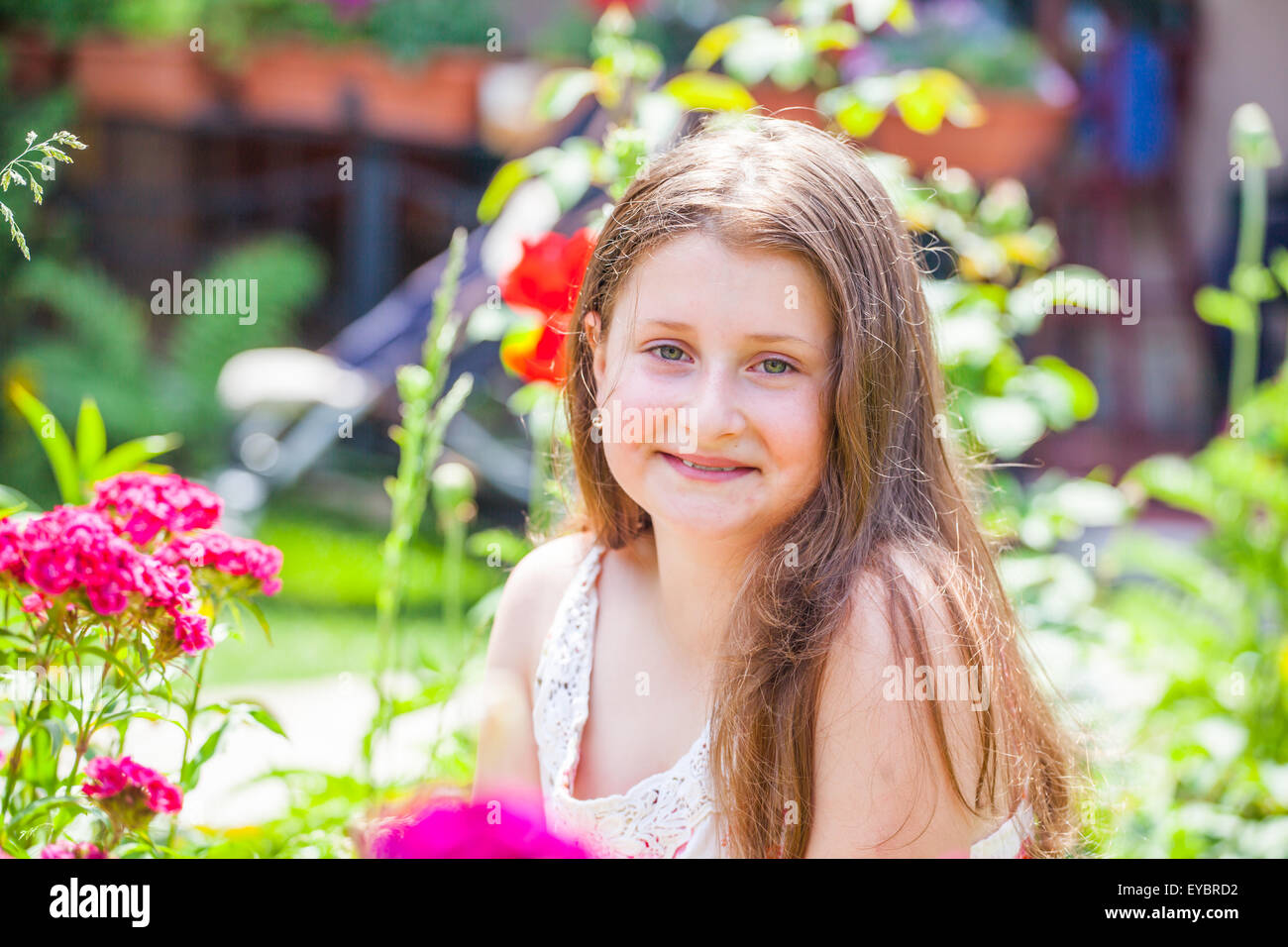 Portrait of a 10 year old girl enjoying the flower garden at home Stock