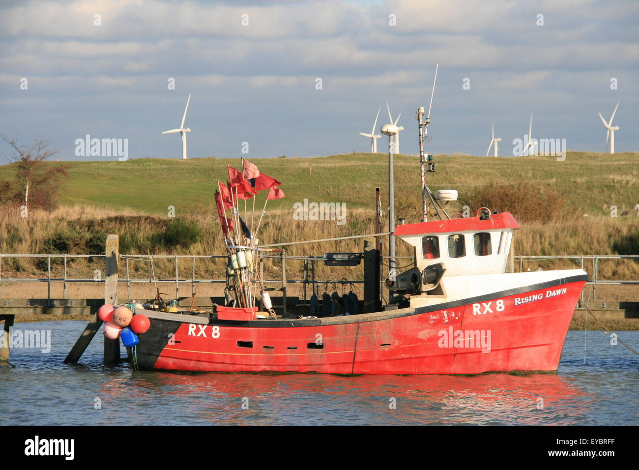 A RED AND WHITE FISHING BOAT RX8 RISING DAWN MOORED IN BRIGHT SUNSHINE AT THE VILLAGE OF RYE HARBOUR EAST SUSSEX UK Stock Photo