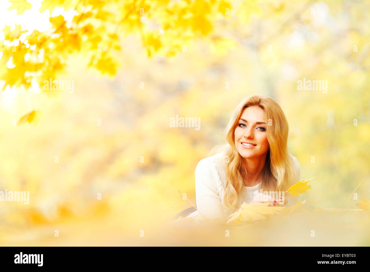 Woman laying on autumn leaves Stock Photo - Alamy