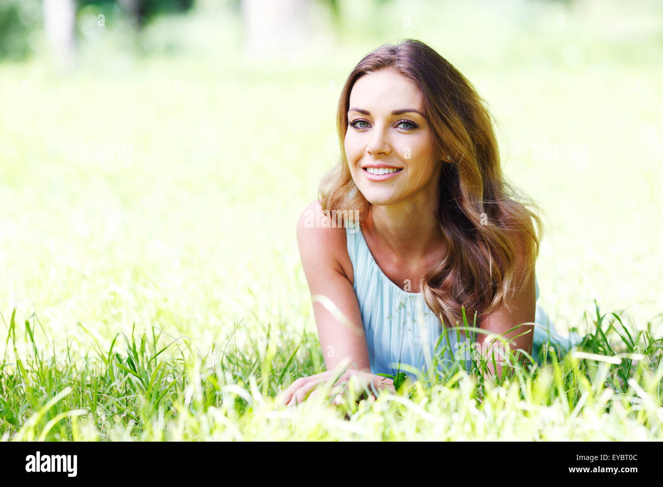 young woman in blue dress lying on grass Stock Photo - Alamy