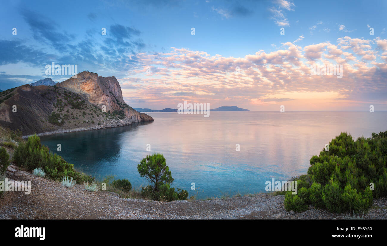 Beautiful summer sunset at the sea with mountains, trees and blue sky in Crimea Stock Photo