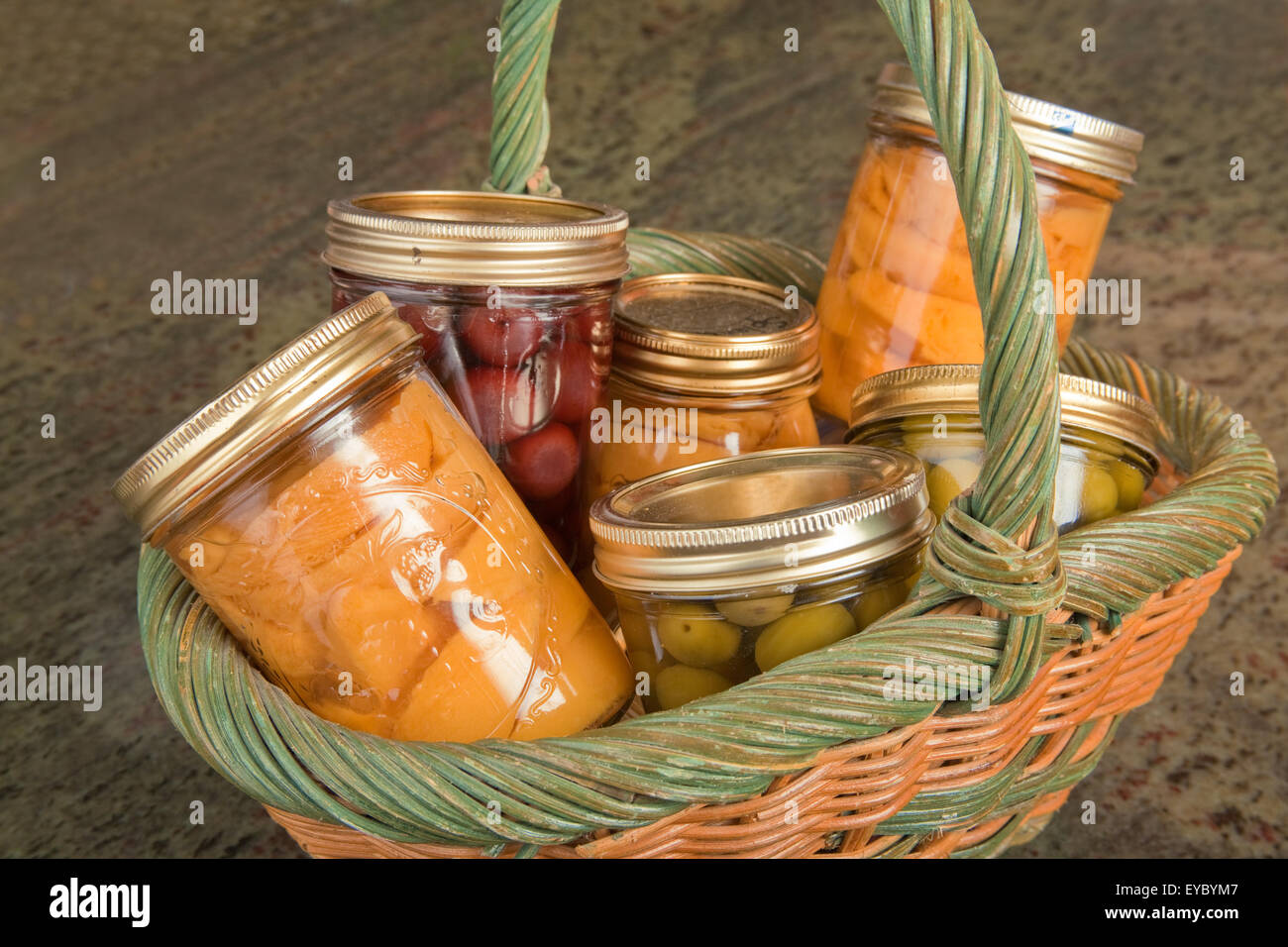 Wicker basket of home canned foods (peaches, olives and cherries) in
