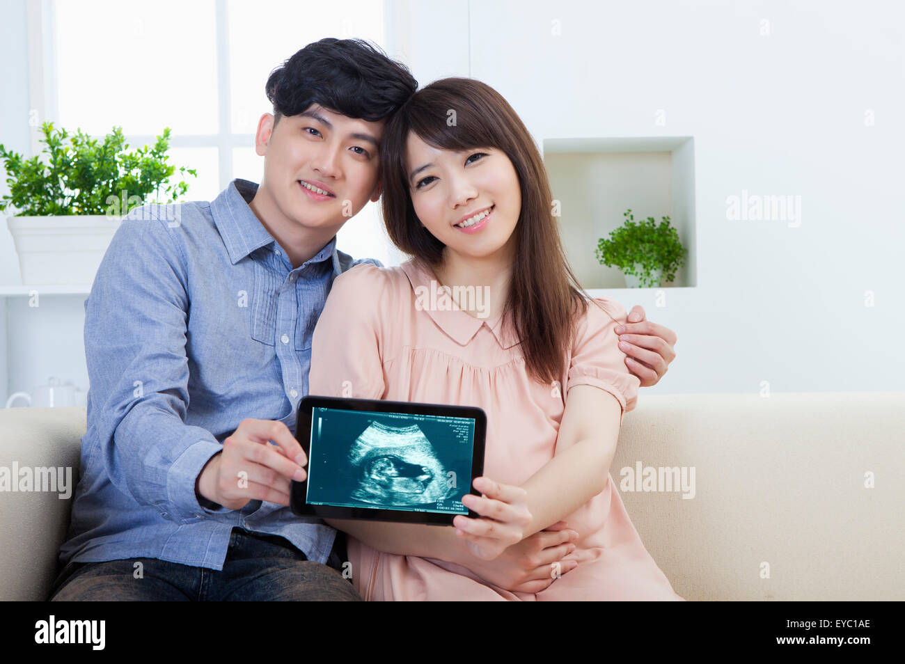 Young man and pregnant woman holding a photo with smile together Stock ...