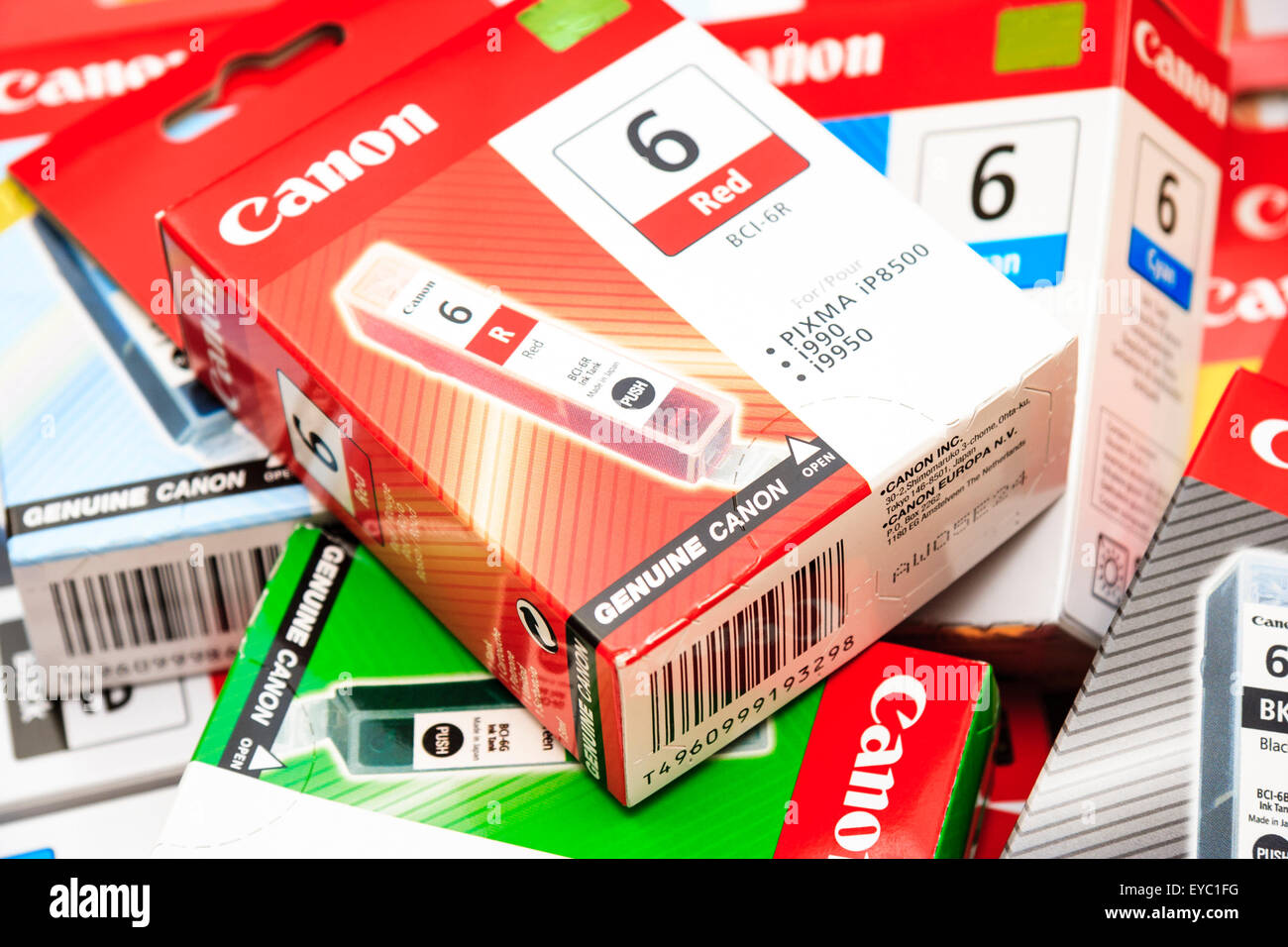 Canon printer ink boxes each housing a color ink cartridge. Scattered