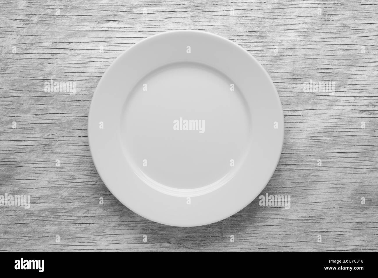 Empty white plate on wooden table Stock Photo