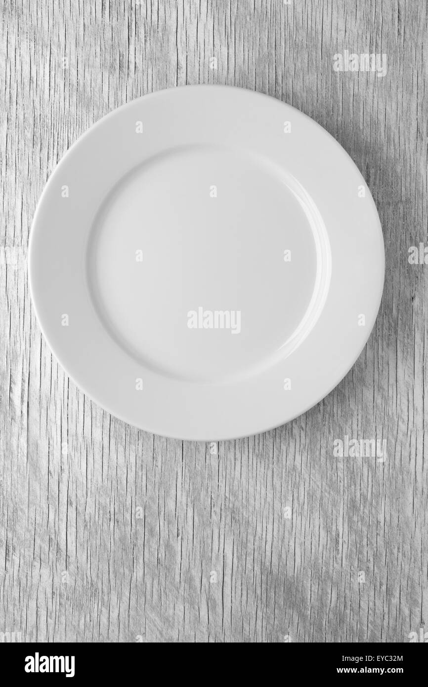 Empty white plate on wooden table Stock Photo