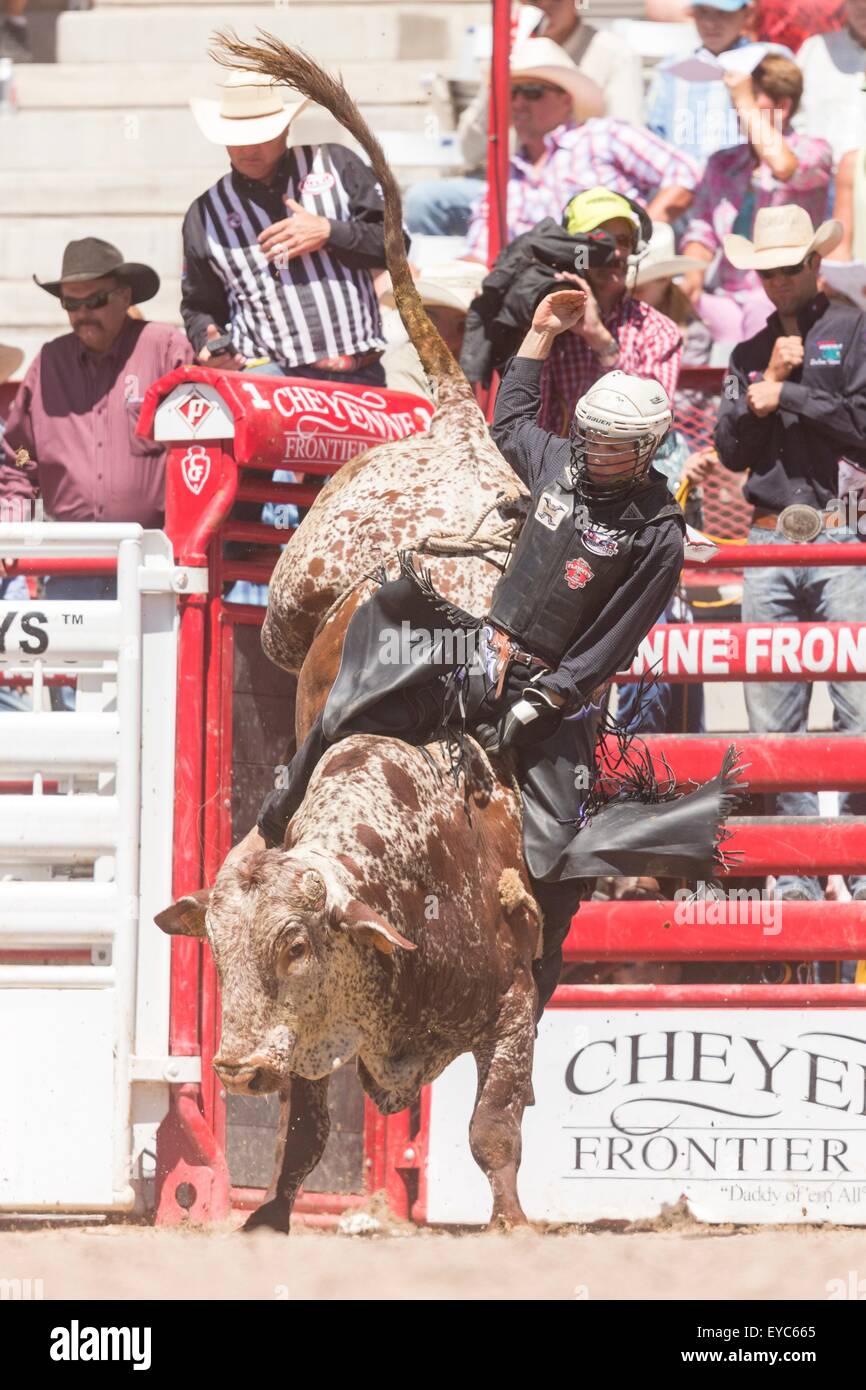 Cheyenne, Wyoming, USA. 26th July, 2015. Bull rider Jeff Bertus hangs on during the Bull Riding finals at the Cheyenne Frontier Days rodeo in Frontier Park Arena July 26, 2015 in Cheyenne, Wyoming. Frontier Days celebrates the cowboy traditions of the west with a rodeo, parade and fair. Stock Photo