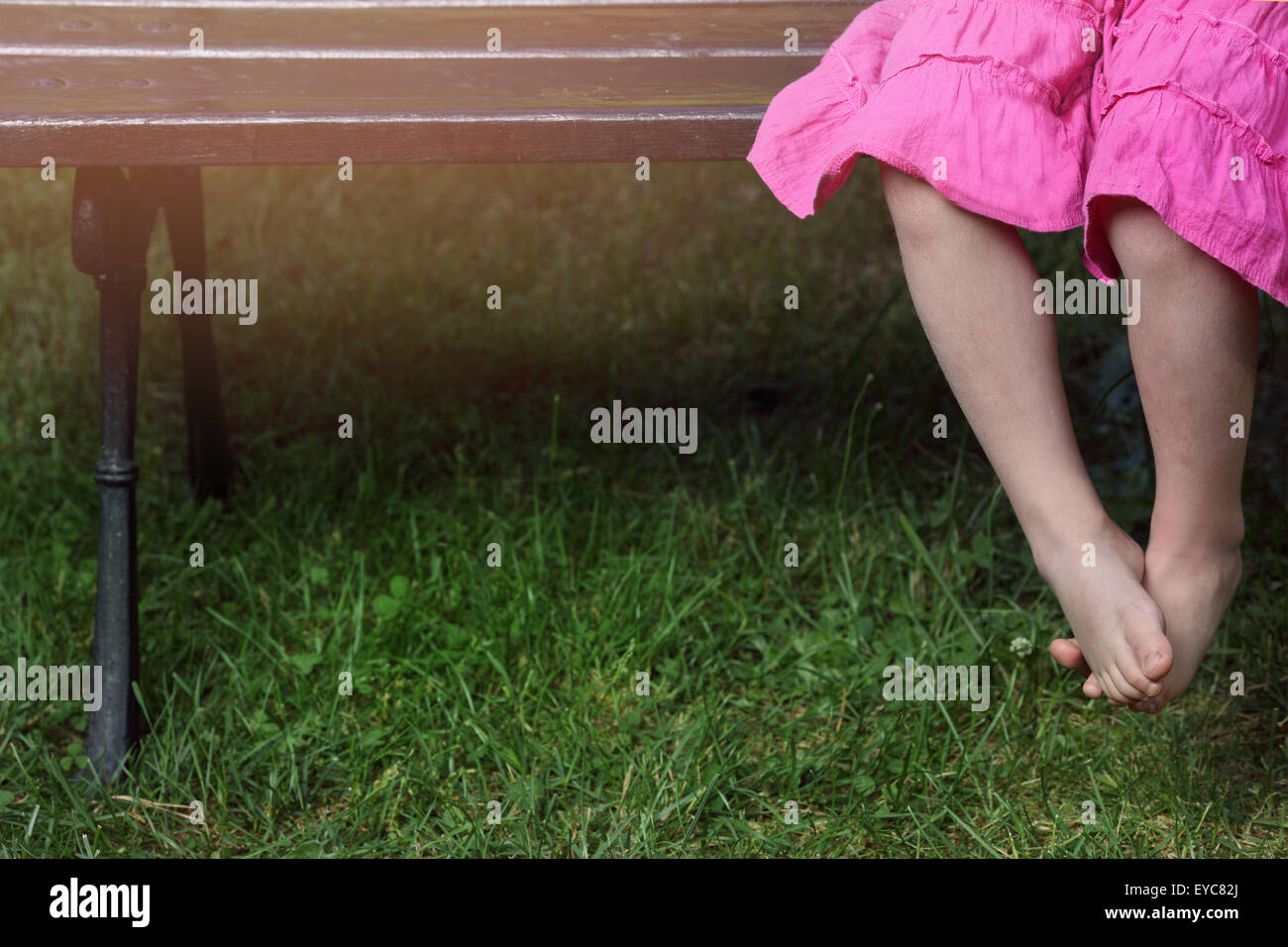 girl in a pink dress sitting on the bench Stock Photo - Alamy